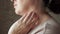 Side view of woman touching her mole on her neck