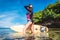 side view of woman in wetsuit with surfboard posing in ocean at Nusa dua Beach