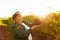 Side view of woman winemaker with hat shows a large red grape