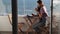 A side view on woman working on digital tablet on the terrace near the sea