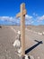 Side view of wooden post with directional arrow indicating path in desert landscape. Routes and trails in extreme nature