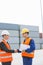 Side view of workers shaking hands in shipping yard