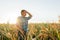 Side view of a Worried corn farmer looking over at cornfield in bad condition,