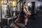 Side view of young adult confident crossfit man standing and doing trx exercises in the gym alone, training chest, workout on