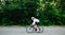 Side view of young athletic woman cycling on professional bike in a white helmet