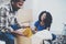 Side view of young black american african couple with moving boxes in new apartment.Cheerful couple sitting in empty new