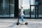 Side view of a young businesswoman riding electric push scooter. Female in cycling helmet driving electrical scooter against