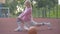 Side view of young confident Caucasian woman warming up before basketball game on outdoor court. Portrait of blond