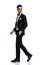 Side view of young elegant groom in tuxedo walking