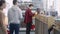 Side view of young male customer buying goods at cashier in hardware store. Blurred Caucasian clients standing in queue