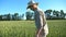 Side view of young male farmer in hat going on cereal plantation at sunny summer day. Profile of confident man walking