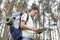 Side view of young man with backpack reading map in woods