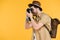 side view of young man in hat with backpack photographing with camera