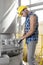 Side view of young manual worker using wrench on industrial machine