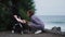 Side view of young mother pushing baby stroller over summer beach background