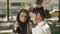 Side view of young muslim couple eating lunch in park.