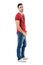 Side view of young relaxed casual man in red t-shirt and jeans looking at camera