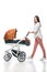 side view of young woman with infant baby in baby carriage