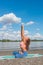 Side view of young woman practice yoga stretch and breathing at river beach  sunny summer day healthy lifestyle concept