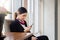 Side view of young woman using smartphone device, female receptionist hands typing text message via cellphone, teenager girl relax