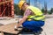 Side view of a young worker hammering a nail into wood during wo