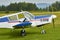 Side view of  Zlin Z-43 four-seat light airplane standing on a grass runway.  Low-wing