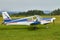 Side view of Zlin Z-43 four-seat light airplane standing on a grass runway. Low-wing