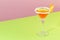 Sidecar alcoholic cocktail with cognac, liqueur, lemon juice and ice. Pink and green background, copy space