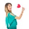 Sideview of beautiful woman holding red heart-shaped lollypop in front of her body