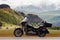 Sideview of black motorcycle touring on a background of mountains range in the snow