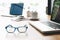 Sideview of office desk with laptop, glasses and other items