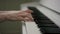 A sideview portrait of a two hands of a woman pianist trying to compose a tune on a gorgeous old-looking piano