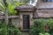 The sidewalk leads to a enter in house with Balinese sculptures in a tropical garden, island Bali, Indonesia