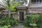 The sidewalk leads to a enter in house with Balinese sculptures in a tropical garden, island Bali, Indonesia