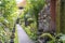 The sidewalk leads to a enter in house with Balinese sculptures in a tropical garden, island Bali, Indonesia