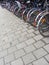 Sidewalk with many bicycles at bike stand