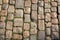 Sidewalk paved with granite stones with grass