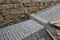 sidewalk, ramp under a stone retaining wall. rows of granite blocks with