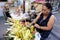 Sidewalk vendor sells Suman or steamed glutenous rice in palm tree leaves and other Filipino delicacies in her makeshift stall