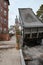 Sidewalk view of a side street in Salem showing parked cars and a dumper truck with a person in the background walking.