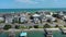 sideways aerial footage of Banks Channel with vast blue ocean water and lush green plants and trees, homes and boats, blue sky