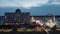 sideways aerial footage of the Carolina Beach Boardwalk with a Ferris wheel, colorful amusement rides, people walking