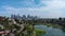 sideways aerial footage of Echo Park Lake with people in pedal boats, lush green trees, plants and grass, skyscrapers
