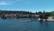 sideways aerial footage Lake Arrowhead Village with rippling blue lake water, boats and yachts, mountains