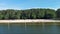 sideways aerial footage of a sandy beach along the banks of Lake Acworth with rippling green waters and people in the water