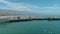 sideways aerial footage of Stearns Wharf Pier with blue ocean water, boats and yachts sailing and people walking and cars driving