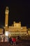 Siena by night. Piazza del Campo and Tower del Mangia illuminated..Tourists in the square.