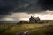 siernhouse, with abandoned house and barn in the background, against stormy backdrop of thunderclouds