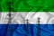 Sierra Leone flag in the background Conceptual illustration and silhouette of a high voltage power line in the foreground a symbol