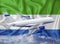 Sierra Leone flag with white airplane and clouds. The concept of tourist international passenger transportation